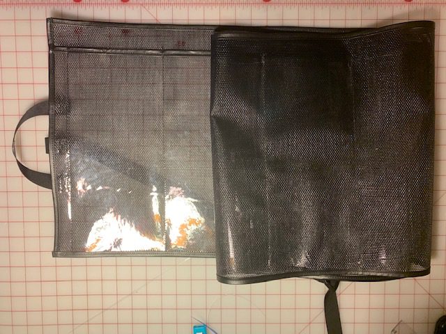 A black bag sitting on top of the floor.