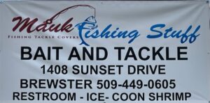 A sign for the fishing shop that is located in the town of sunset.
